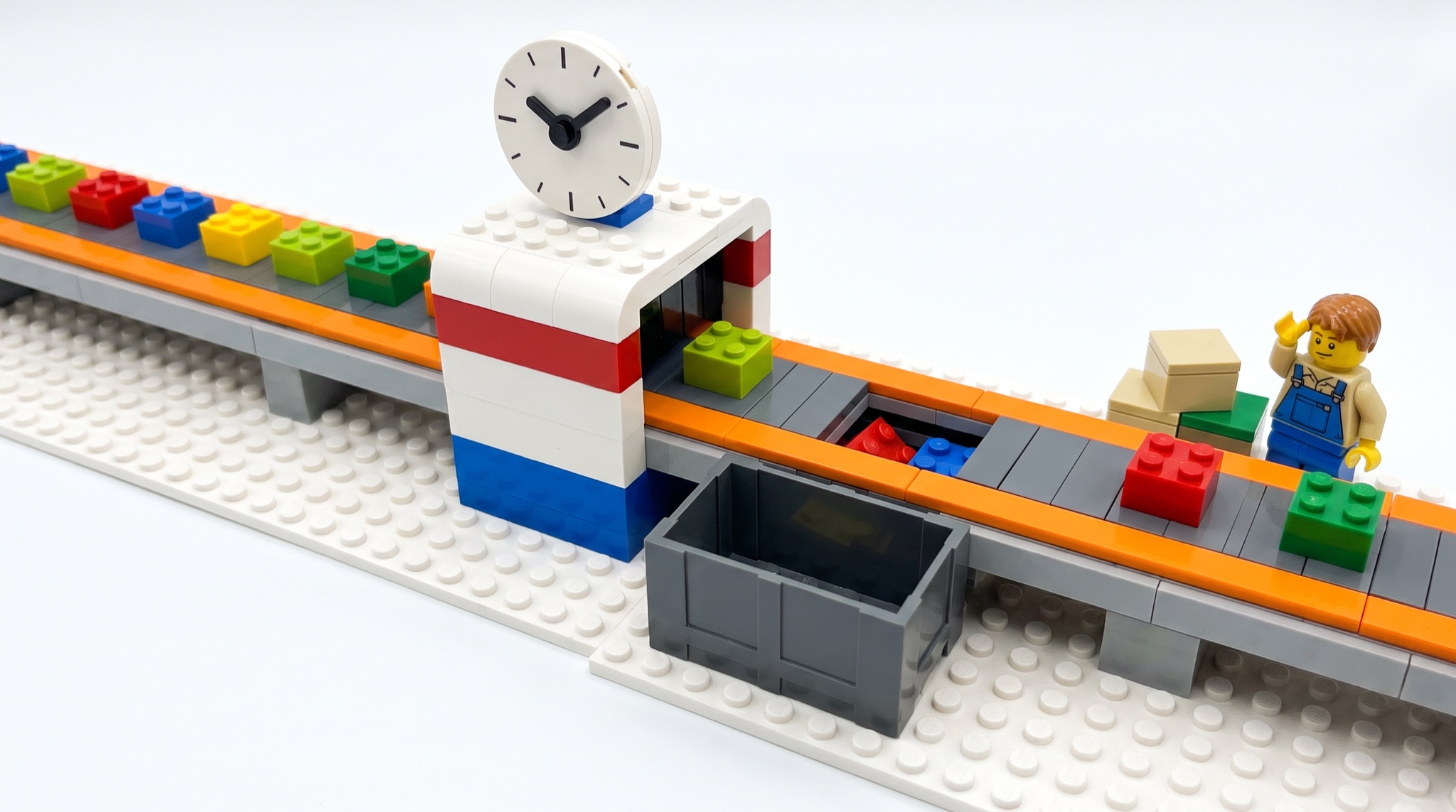 A Lego conveyor belt scene where bricks drop through a gap under a blank clock into a dark bin while a minifigure at the end scratches its head at a small stack of boxes.